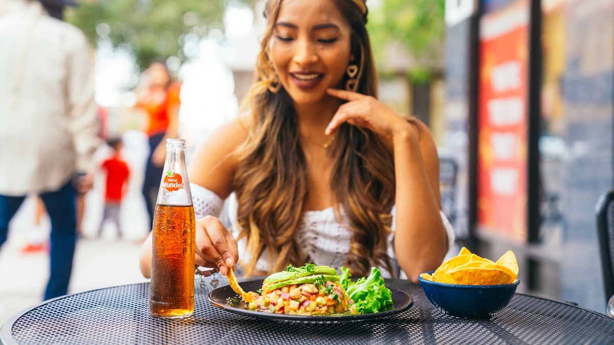 a woman sitting at a table with a plate of food